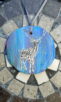 White stag on wood slice