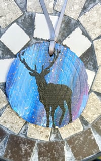 Black stag on wood slice