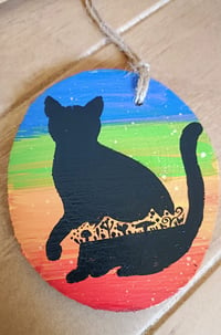 Image 2 of Rainbow meadow cat on wood slice