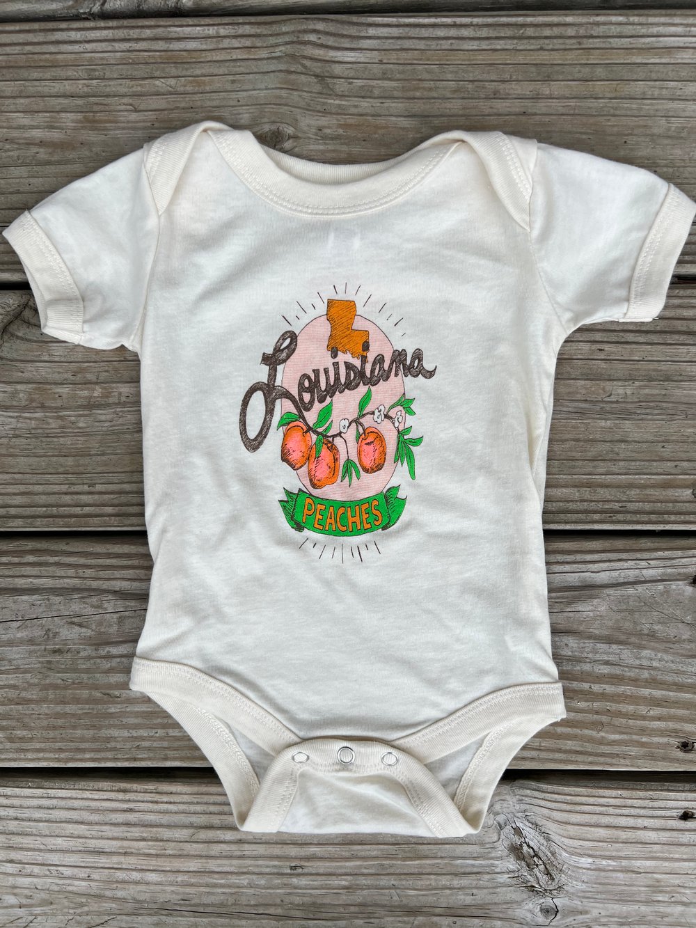 Image of Baby Louisiana Peaches Onesie on Cream