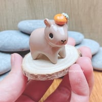 Image 1 of capybara with orange ceramic figurine