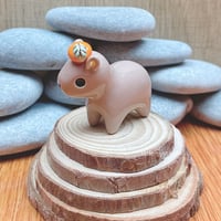 Image 3 of capybara with orange ceramic figurine