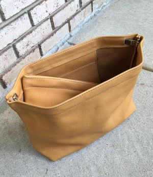 Image of golden wheat leather spring frame clutch