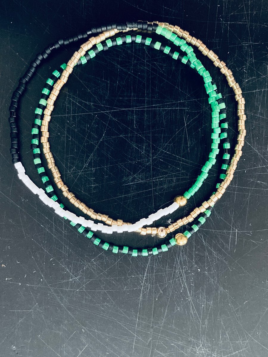 Image of Green, White, Black, Gold Stack Bracelets. 
