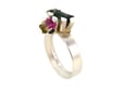 A contemporary ring featuring green and watermelon Tourmalines in a silver claw settings