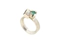 A contemporary ring featuring Orange Tourmaline and emerald in a silver claw setting