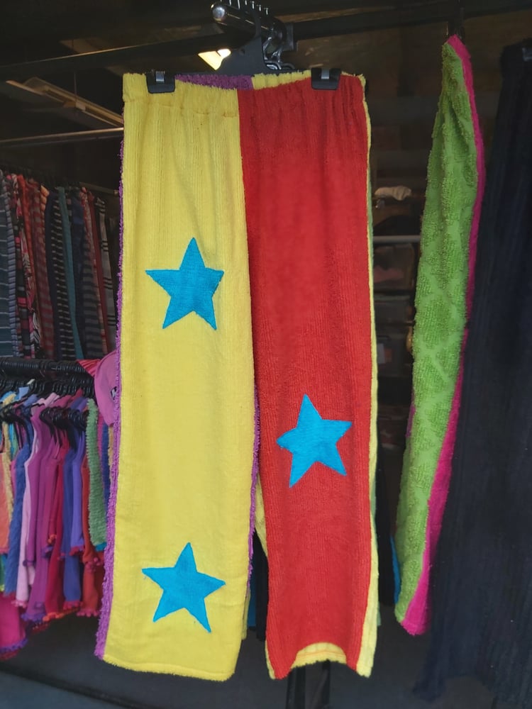 Image of Chenille Star Pants in yellow/orange with blue stars. Purple/yellow on back