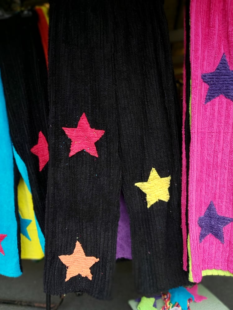 Image of Black chenille pants with orange/red/yellow stars