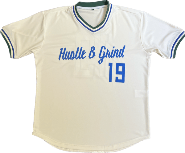 Image of Hustle & Grind Baseball Jersey White w/Royal Blue letters & Green trimming. 
