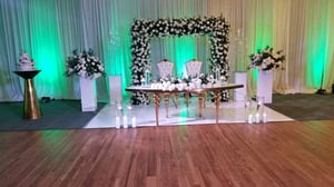 Image of Stage design with green  and white silk  flowers  