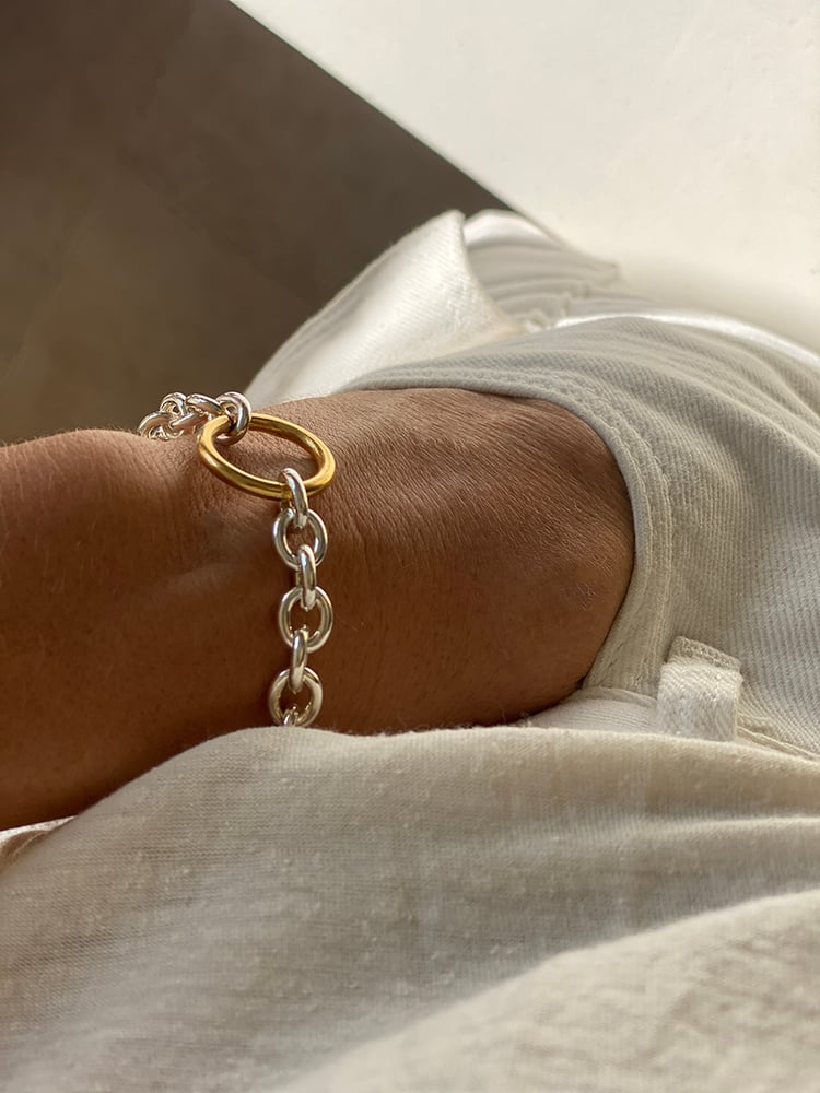 CHARMING IN ITS SIMPLICITY 
With our beloved combination of gold and silver 

The sterling silver oval lightweight chainlink is gold bond-ed by a bold 18k gold plated circle closure, which is the ornament and clasp in the same time.