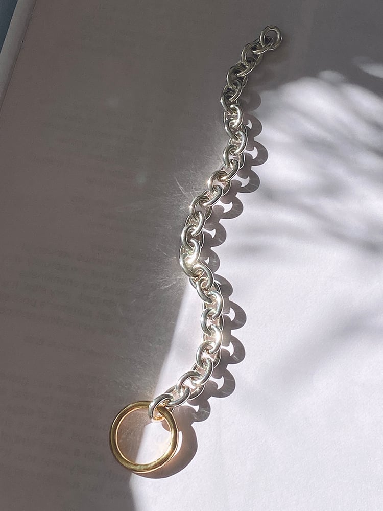 CHARMING IN ITS SIMPLICITY 
With our beloved combination of gold and silver 

The sterling silver oval lightweight chainlink is gold bond-ed by a bold 18k gold plated circle closure, which is the ornament and clasp in the same time.