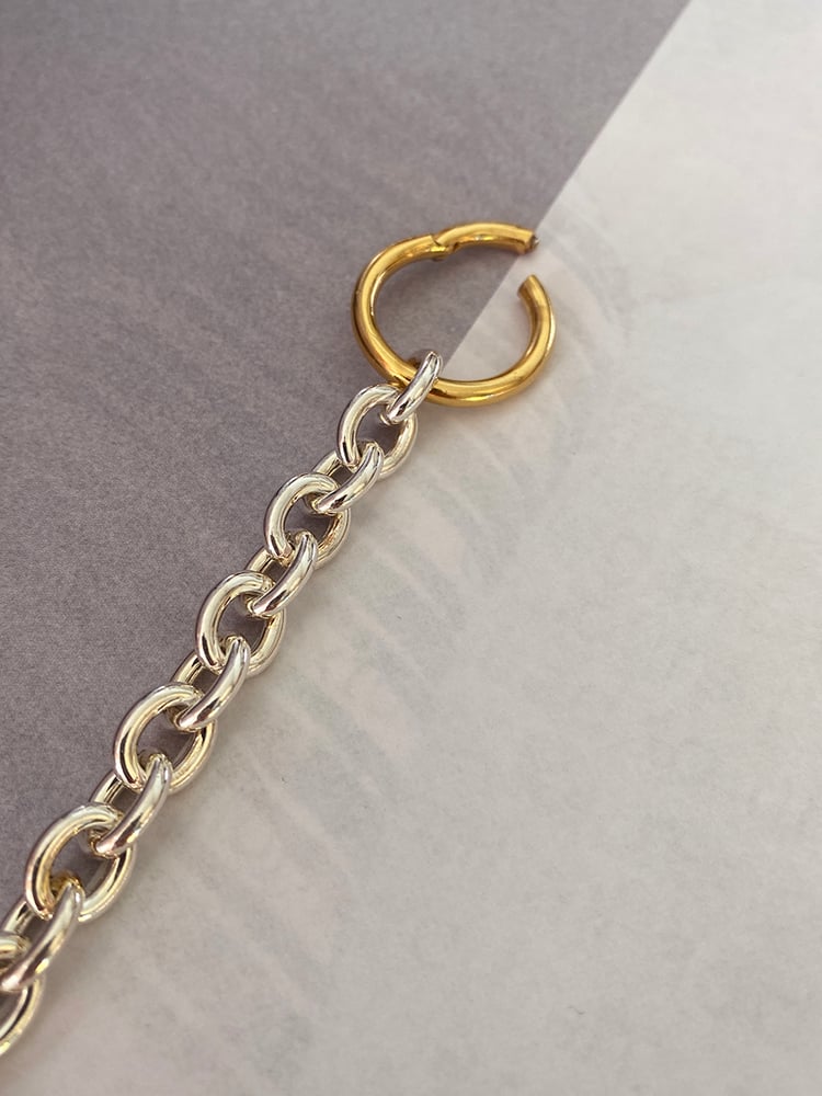 CHARMING IN ITS SIMPLICITY 
With our beloved combination of gold and silver 

The sterling silver oval lightweight chainlink is gold bond-ed by a bold 18k gold plated circle closure, which is the ornament and clasp in the same time.