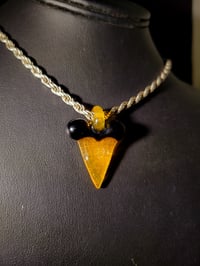 Image 1 of Orange & black shark tooth pendant.