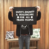 Image 1 of Safety, Dignity and Healthcare for all trans people wall hanging