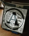Reverse gilded and chipped initial