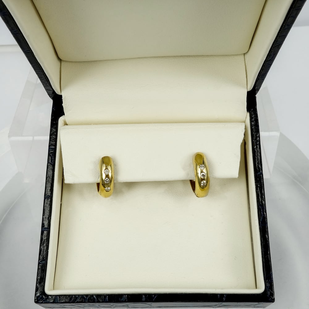 Image of 9ct yellow gold diamond set huggie earrings. SH5