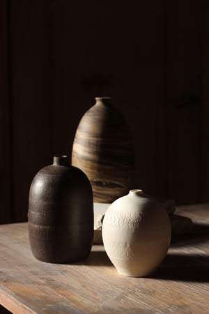 Image of bottle vase in raw black clay