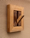 Wood wall hook with decorative frame.