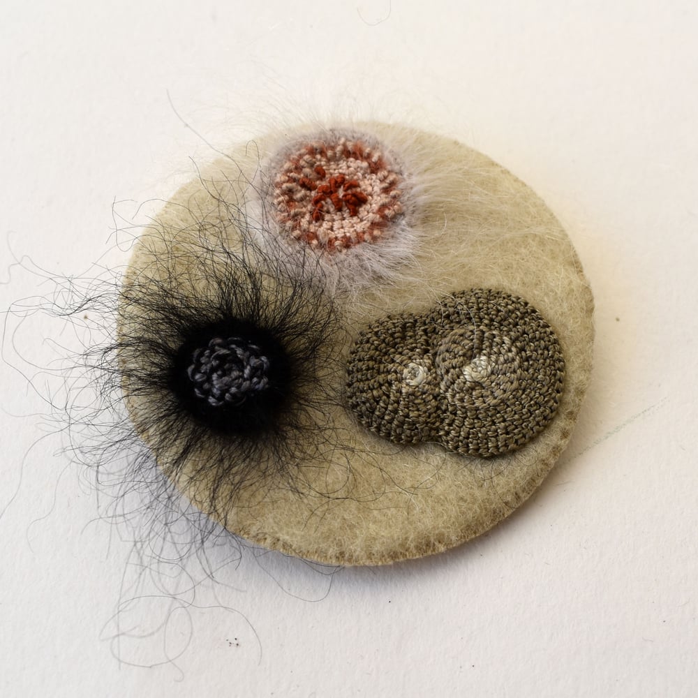 Image of Small felt brooch with embroidered moulds