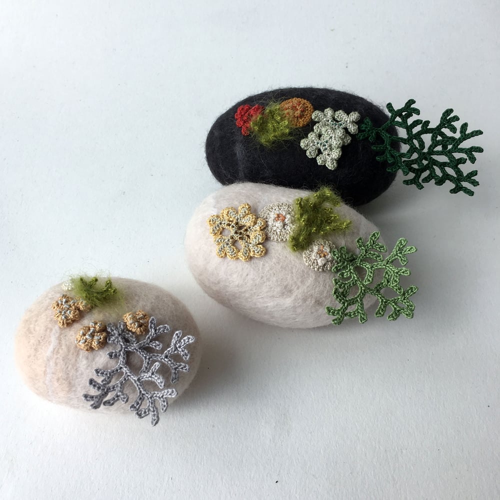 Image of two felt stones/ large black and small pale peach