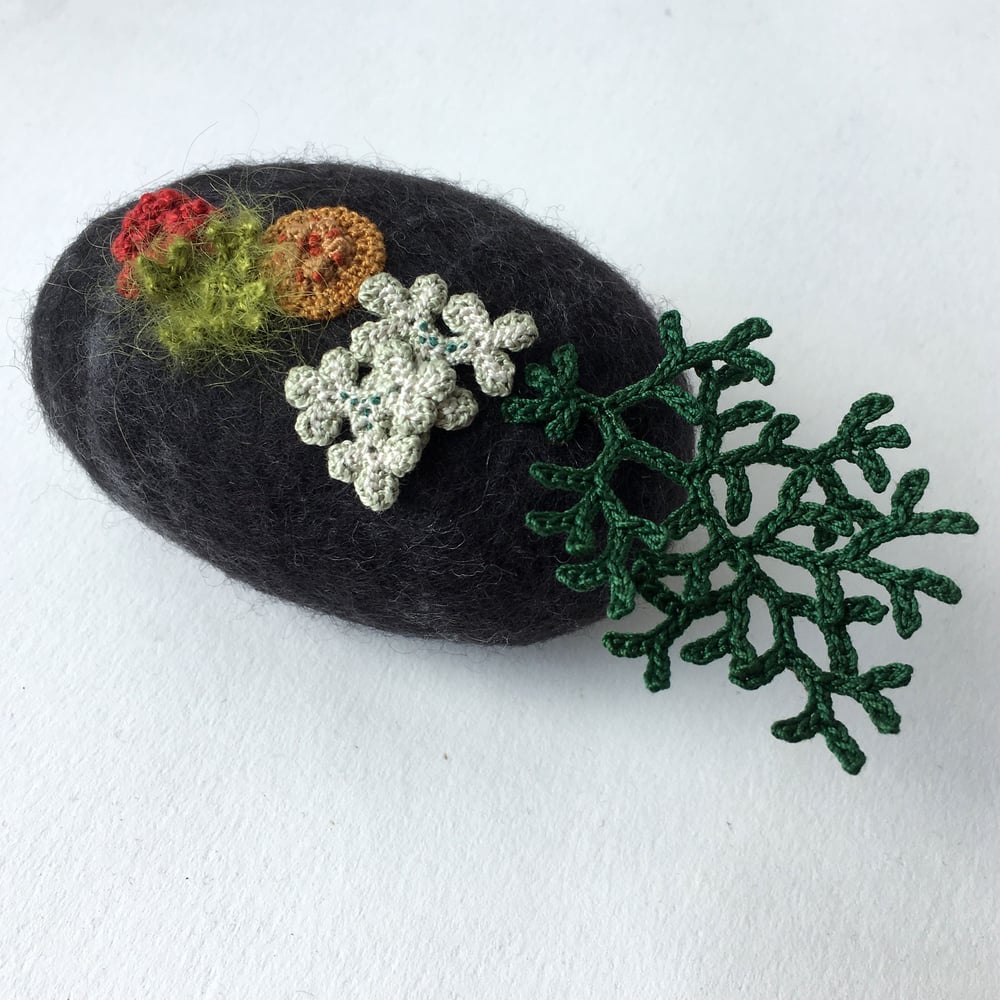 Image of two felt stones/ large black and small pale peach