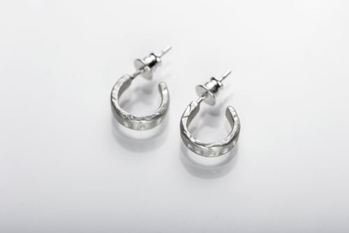 Image of thin round silver earrings with inscription in Latin