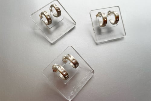 Image of thin round silver earrings with inscription in Latin