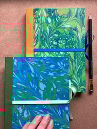 Image 4 of Sky Blue, Pale Blue & Green Hand-Marbled Large Plain Notebook- Imbolc/Snowdrop Pattern