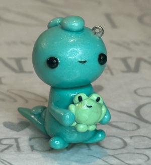 Image of Dino Holding A Frog Charm