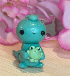 Image of Dino Holding A Frog Charm