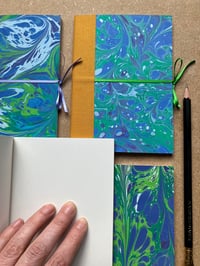Image 1 of Violet, Fresh Green and White Hand-Marbled Plain A6 Notebooks- Bluebell Pattern
