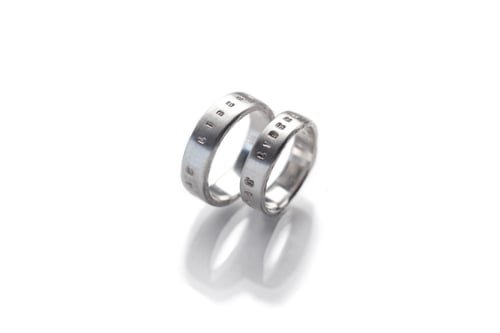 Image of silver wedding rings with inscription in Latin