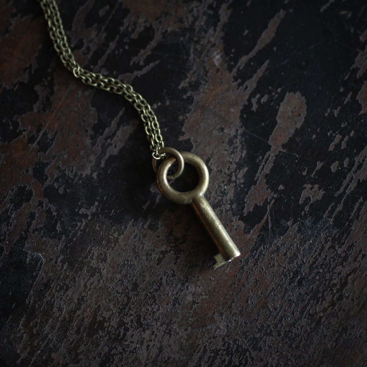 Small circular brass key necklace on brass chain