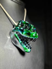 Image 1 of Expiramental green T-Rex skull pendant with galaxy teeth.