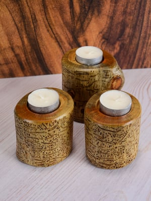 Image of Set of three Spruce wood tea light candle holders with natural markings