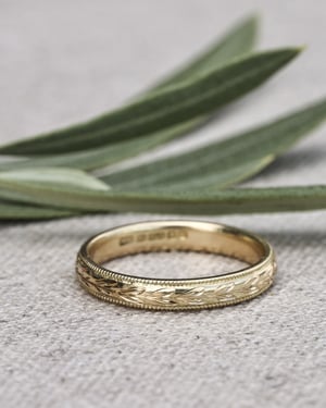 Image of 18ct yellow gold 3mm ‘Olive leaf’ and milled edge engraved ring