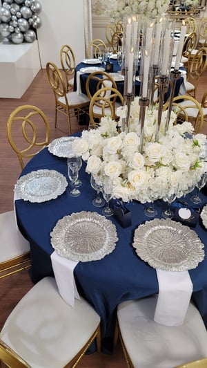 Image of Silver candlelabra with flowers at the base 