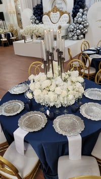 Image 1 of Silver candlelabra with flowers at the base 
