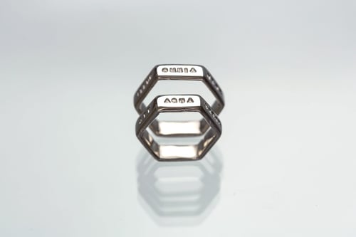 Image of silver hexagon ring with inscription in Latin 