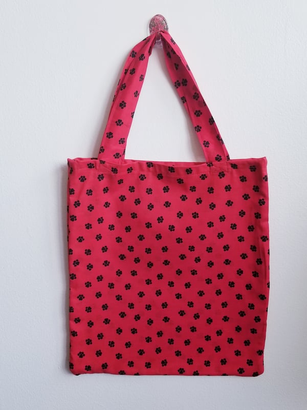 Image of Red tote bag with black paw prints 
