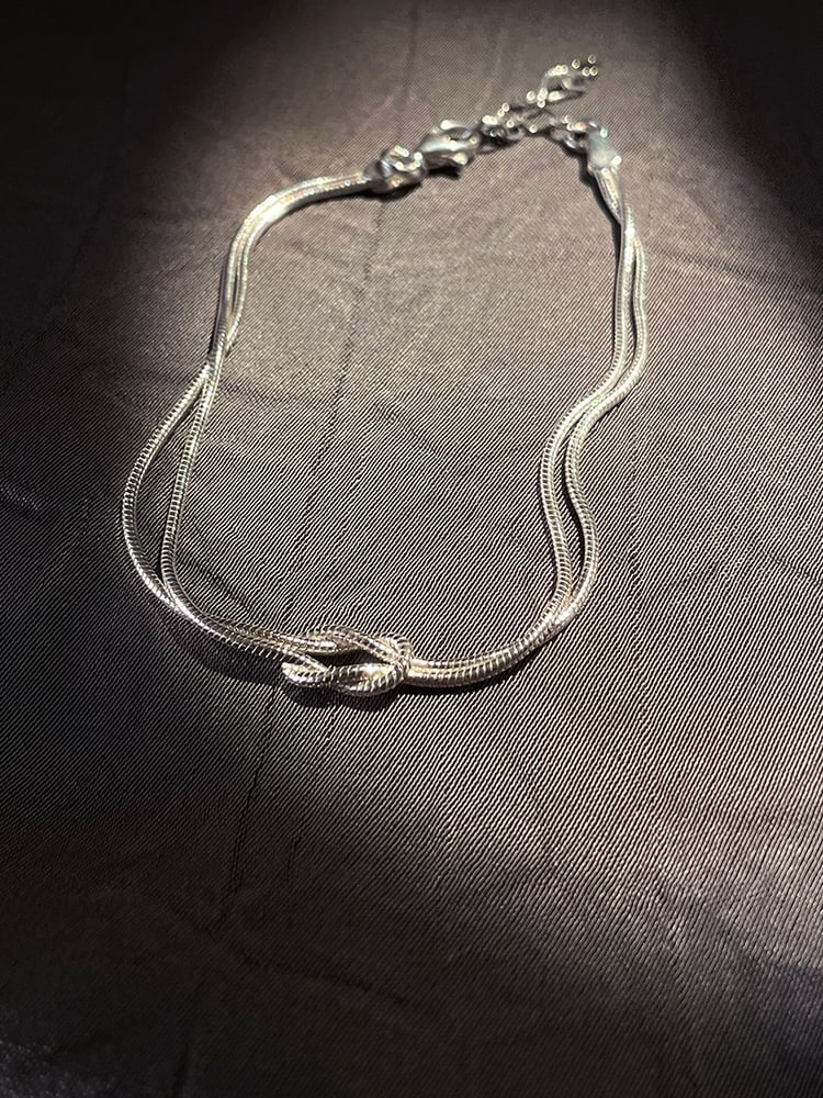 A TINY PRESENCE THAT FEELS LARGER

IT REMINDS YOU OF THE WARMTH OF SHARED MEMORIES,
THE BONDS THAT MATTER MOST

Two 925 sterling silver thin round chains intertwined which can move fluidly.
Adjustable in length

This bracelet is subtle and refined, an elegant opulent touch of silver addition to any outfit.
 