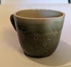 Hand thrown, stoneware mug with spotted green glaze.