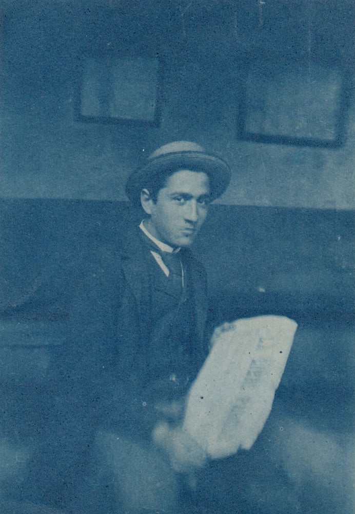 Image of Anonyme: young man reading a newspaper, France ca. 1910