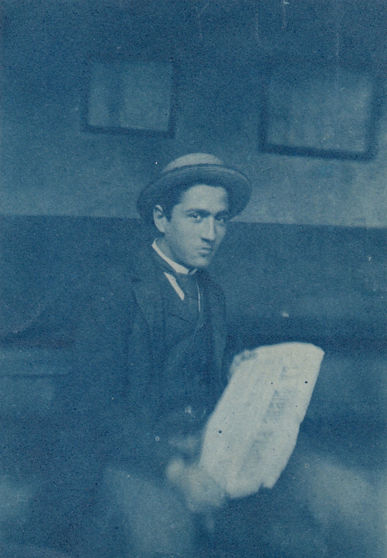Image of Anonyme: young man reading a newspaper, France ca. 1910