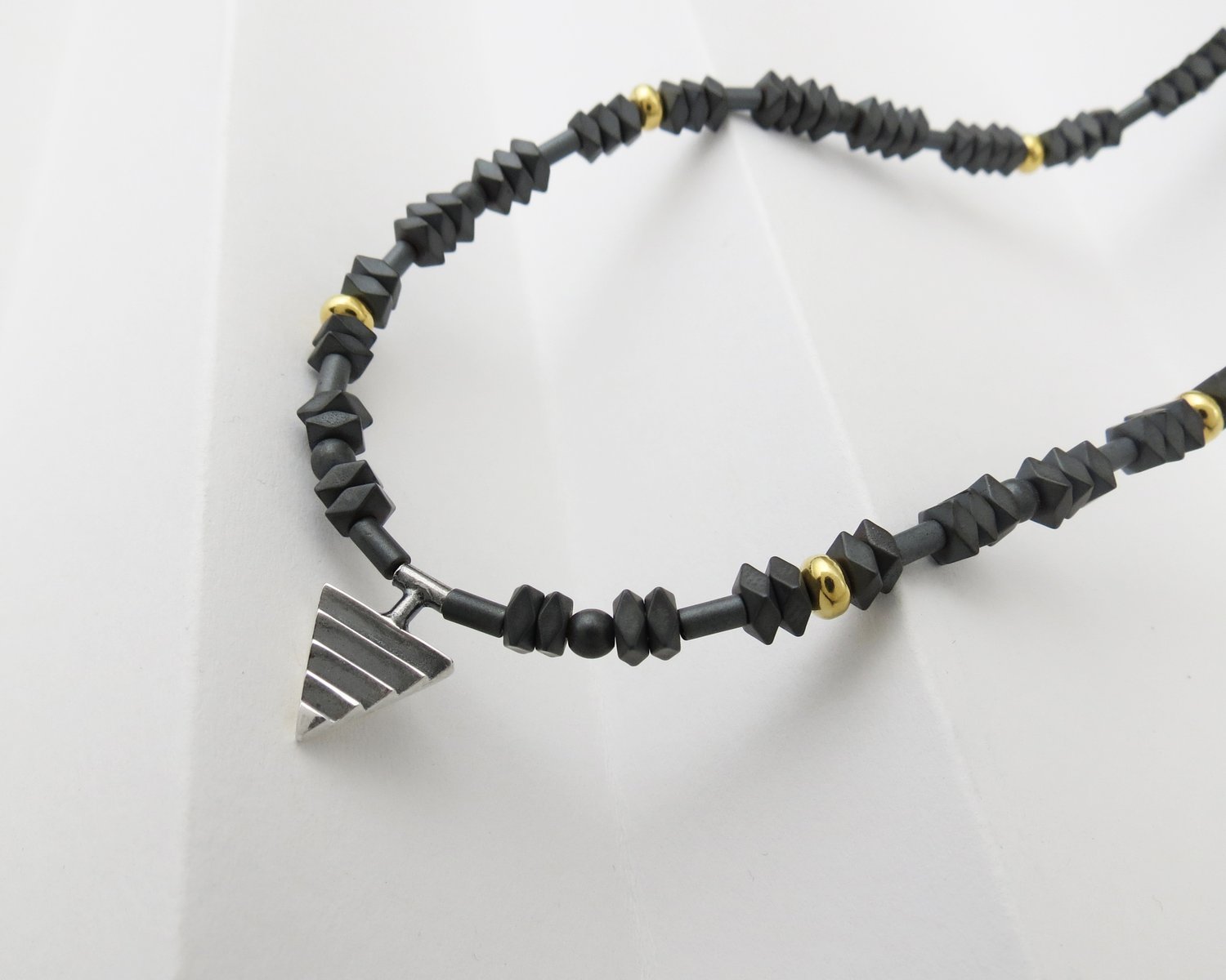 Image of Mono Delta on Hematite and Rolled Gold Beads