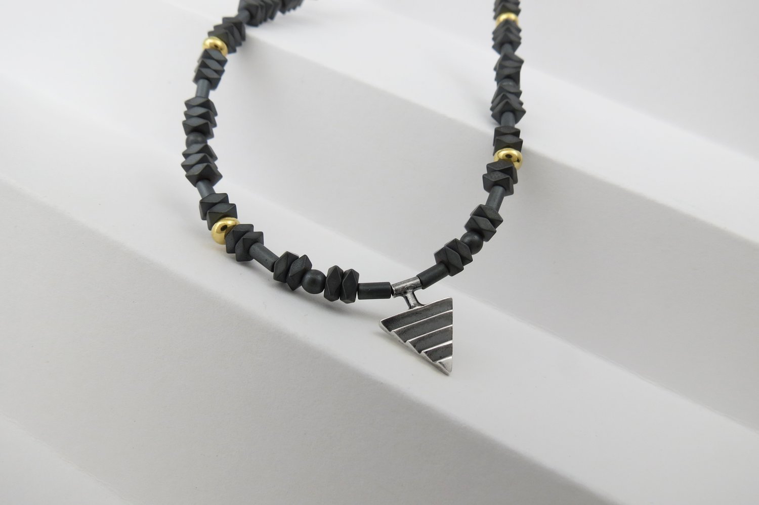 Image of Mono Delta on Hematite and Rolled Gold Beads