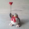 Heart balloon and red scarf penguin.