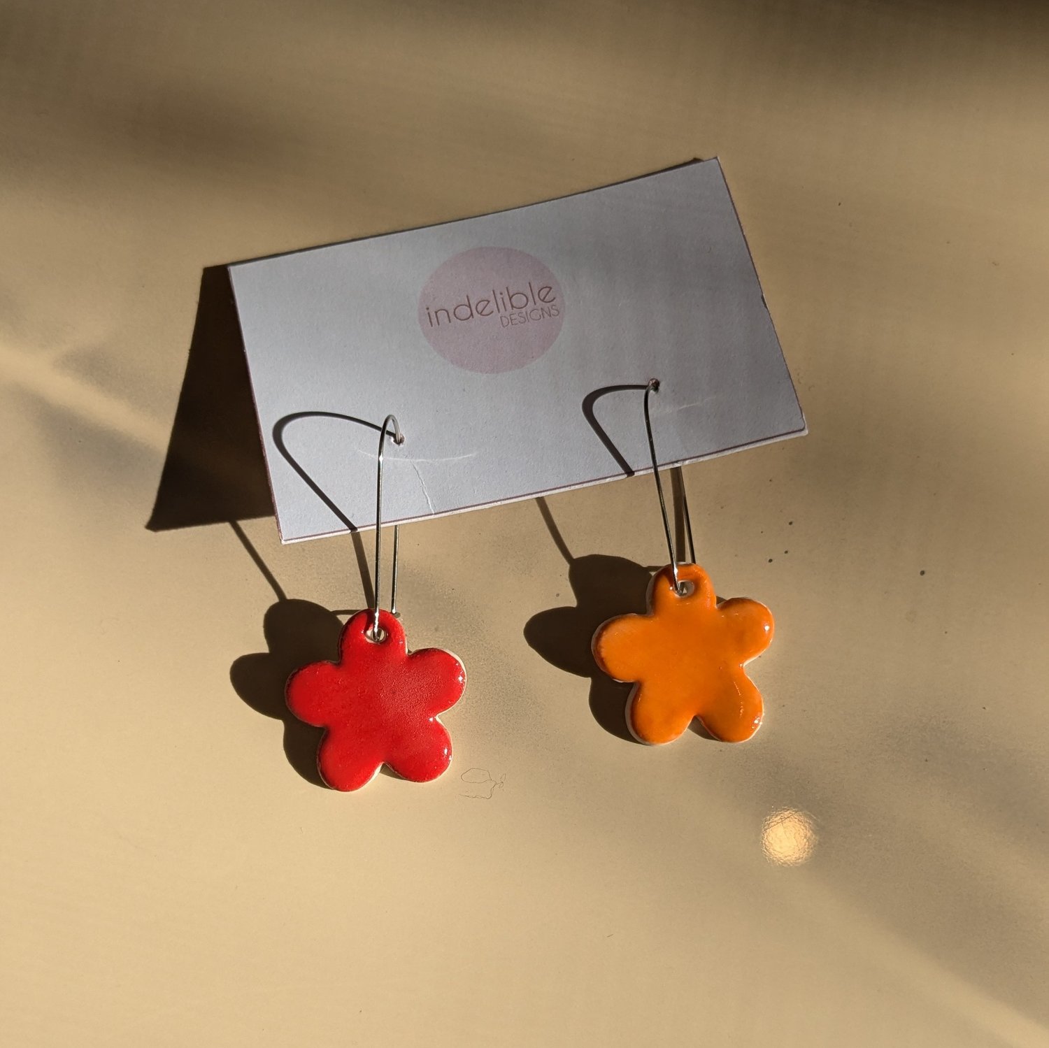 Image of red and orange daisy asymmetrical earrings