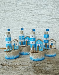 Image 2 of In the blue sea, in the white foam Lighthouse and driftwood house